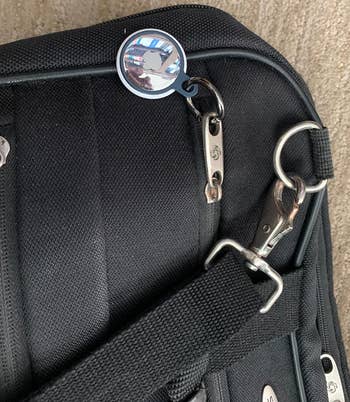 reviewer's airtag attached to their bag via a keyring