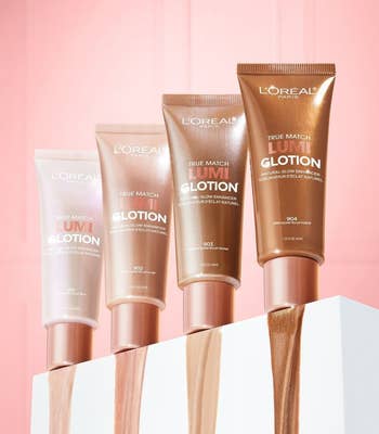 four bottles of the lotion showing their shades on a pink background