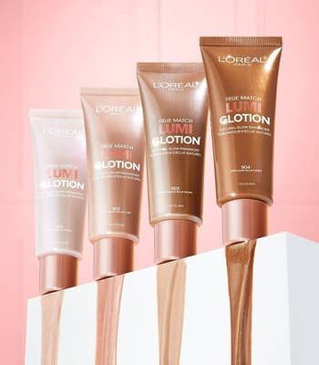 four bottles of the lotion showing their shades on a pink background
