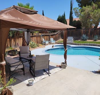 reviewer photo of the brown pop up gazebo next to a pool