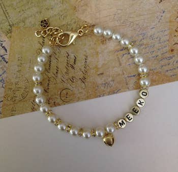a pearl collar with gold-tone letter beads that spell out 