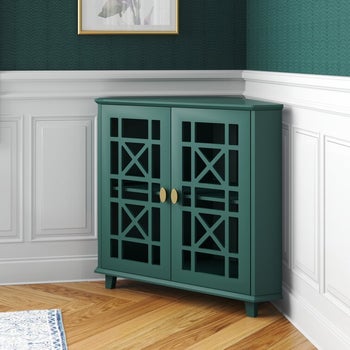 a teal accent cabinet with cutouts on its doors in the corner of a room