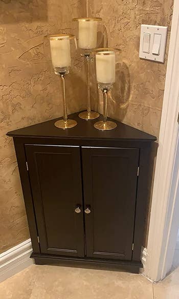 Reviewer image of dark brown short corner cabinet with candles on top
