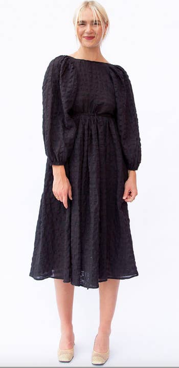model in black dress with scoop neckline