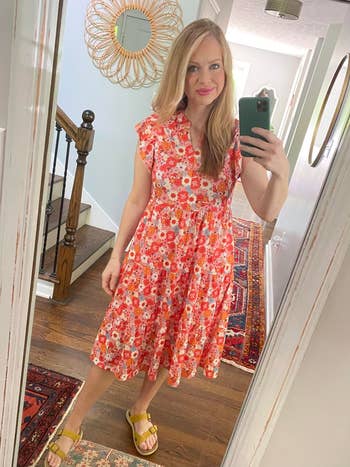 Person successful floral formal taking a reflector selfie successful a hallway, showcasing a casual look
