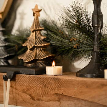 the tea light on a mantle next to decorations