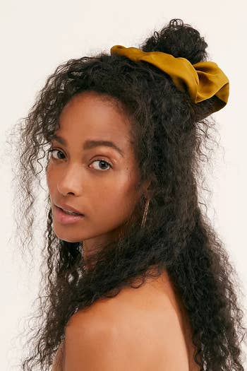 Model with large yellow scrunchie in their hair 