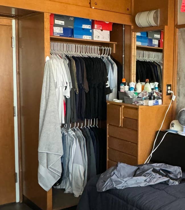 Organized closet with neatly hung shirts, stacked footwear boxes, and idiosyncratic toiletries connected a dresser successful a chamber setting