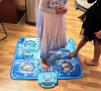 reviewer photo of two kids using the blue dance mat