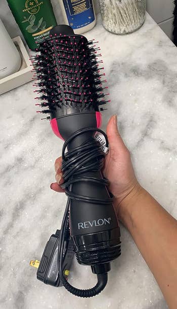 the hair dryer in a reviewer's hand