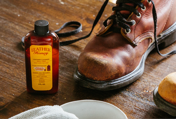 bottle of the cleaner next to a leather boot