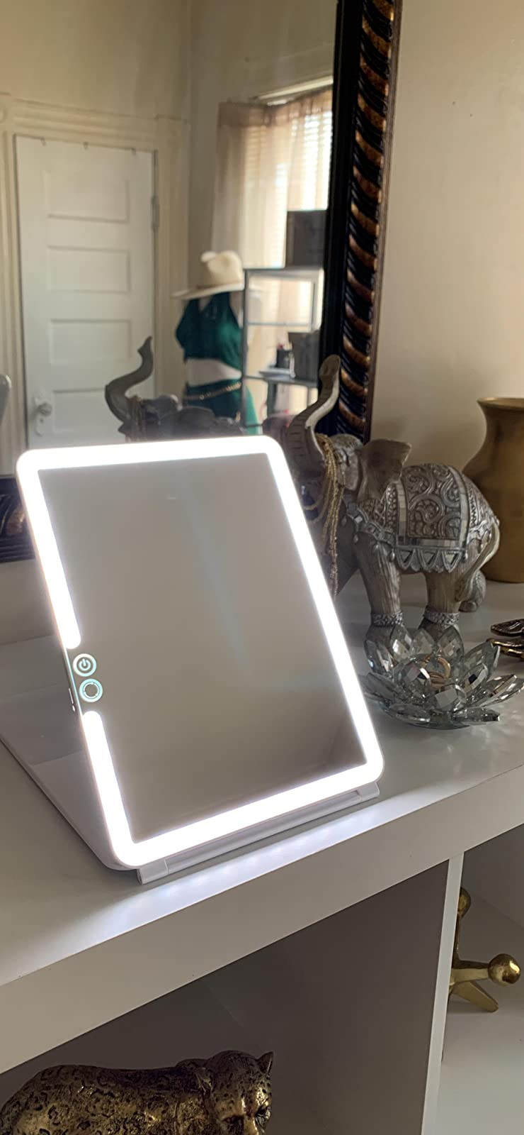 reviewer's lit travel mirror propped up on a table
