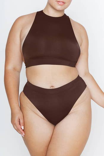 model wearing a brown racing-style swim top with matching bottoms