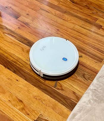 Reviewer's photo of the robot vacuum in the color White on a hardwood floor