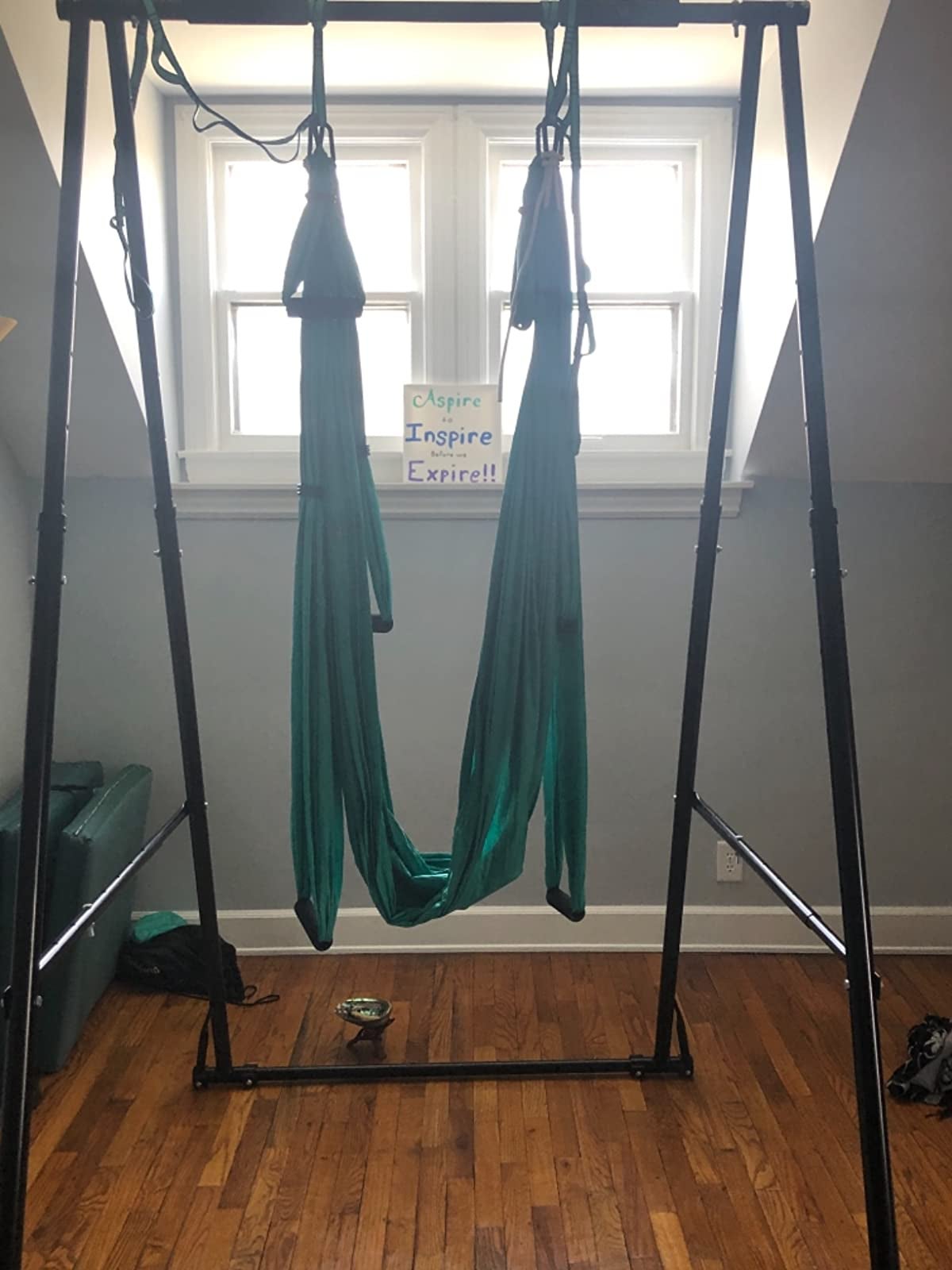 Green yoga sling set up in middle of room