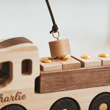 Wooden toy train with a magnetic crane lifting a wooden peg