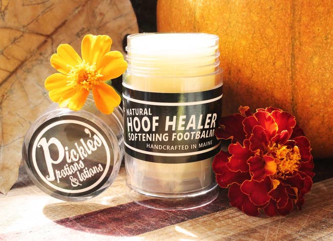 Tube of Natural hoof healer softening foot balm surrounded by flowers