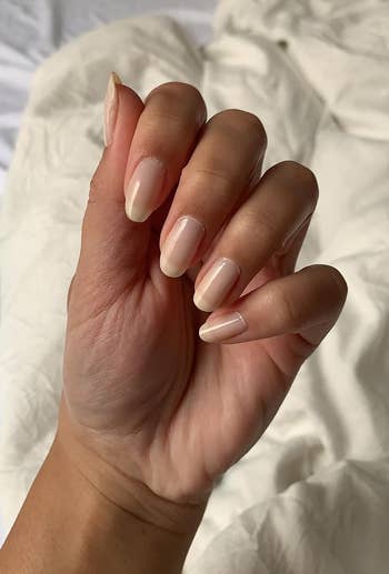 Reviewer displaying manicured nails with glossy finish, likely showcasing a nail product for shopping purposes