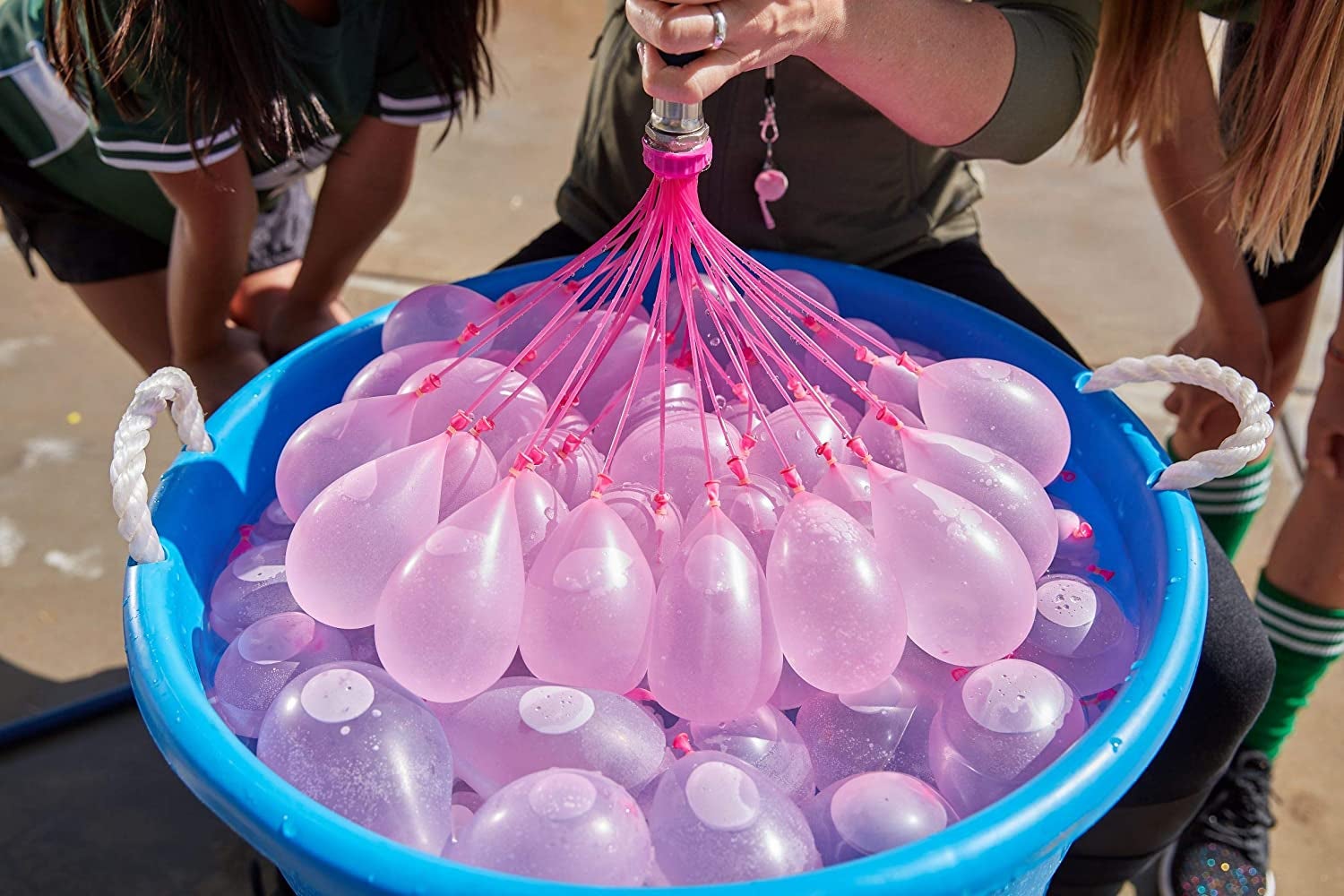 dozens of balloons attached to a hose and filling with water at the same time
