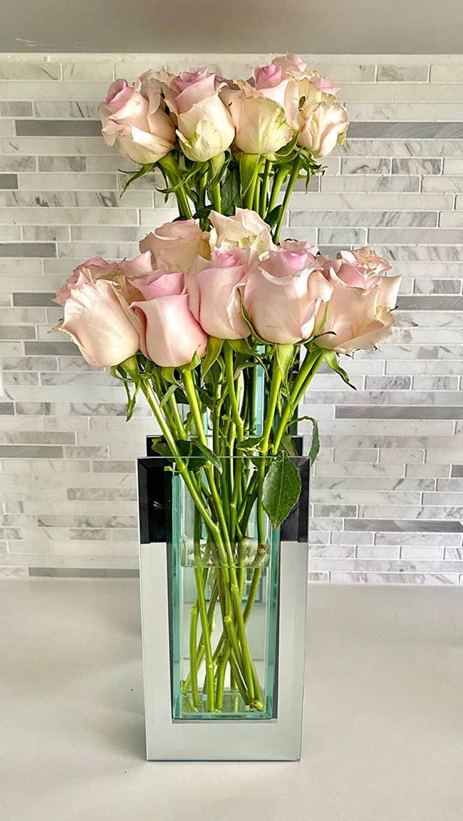 Reviewer image of rectangular mirrored vase with pink roses inside on top of white table
