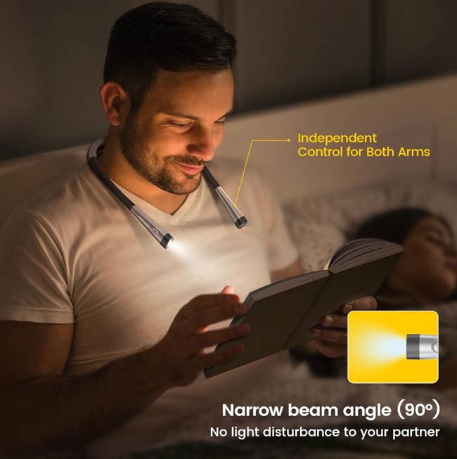 model reading a book with a neck lamp hanging off them while in bed 