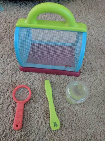 Child's toy bug catching set on a carpet