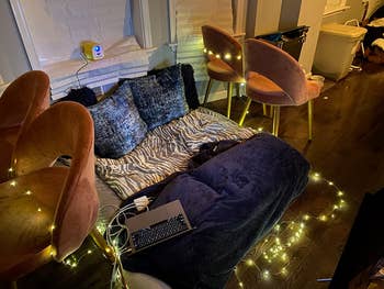 the warm white lights wrapped around a set up of pillows and blankets on a reviewer's floor
