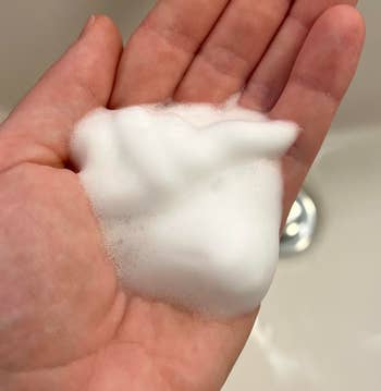BuzzFeed writer holding white foamy soap in hand