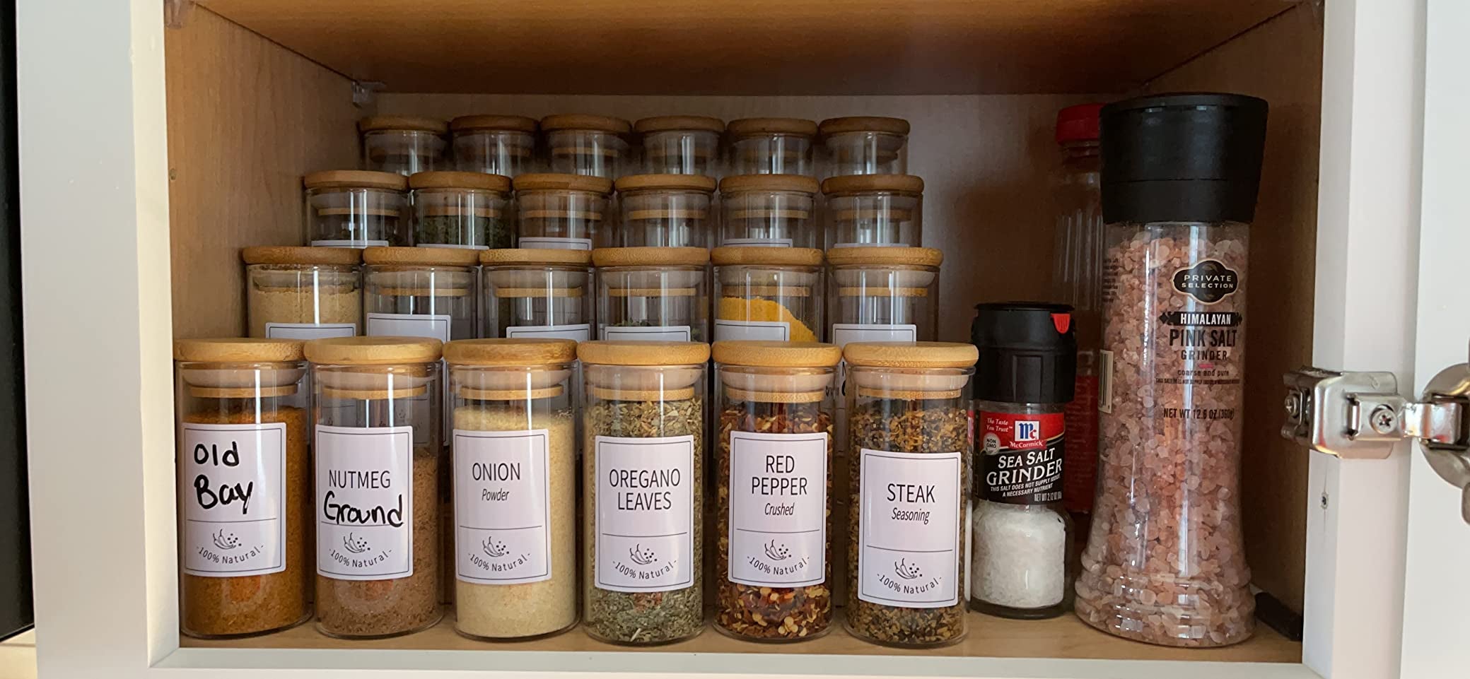 A cabinet filled with various seasonings in glass jars