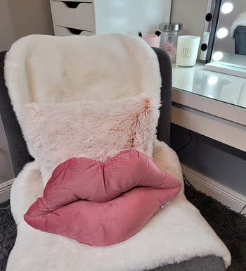 reviewer's light pink lips pillow on a chair 