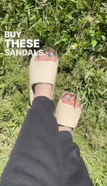 reviewer in cream colored slide on sandals 