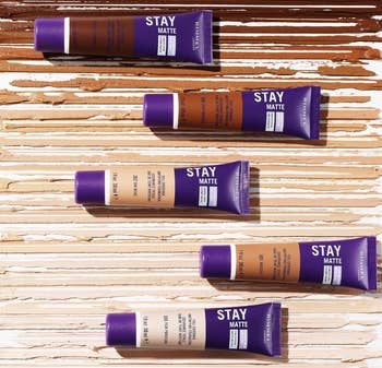 Tubes of Stay Matte instauration  are laid retired  connected  a textured surface, showcasing varying shades for a divers  scope  of tegument  tones