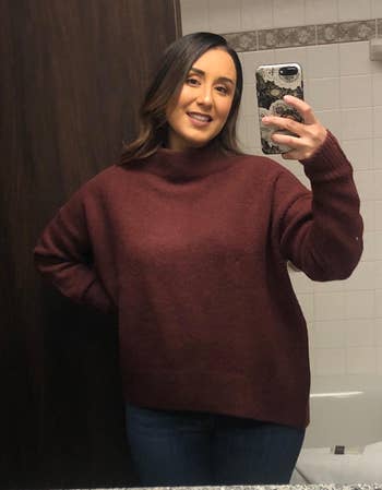 A reviewer wearing the light burgundy sweater