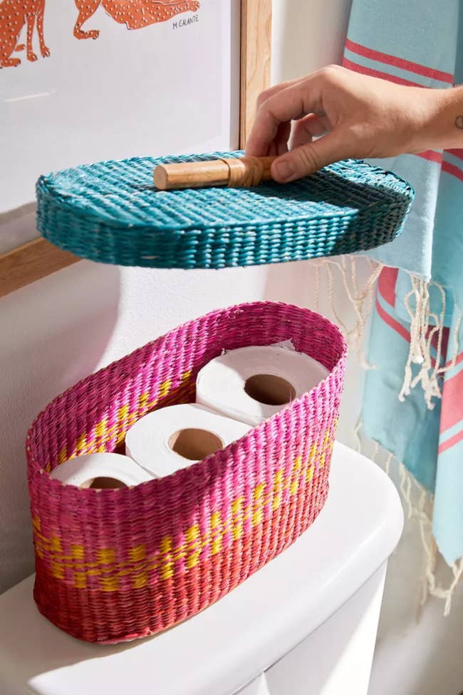 colorful oval basket with three rolls of toilet paper inside