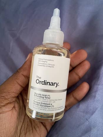 The Ordinary Glycolic Acid 7% Exfoliating Toner held in a hand, displaying its label