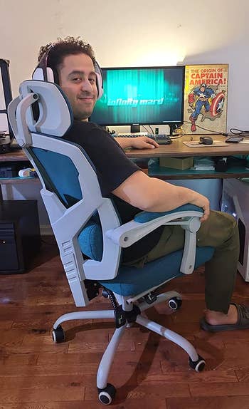 a reviewer sitting in the chair in blue in front of a desk