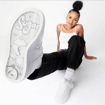 another model wearing the white sneakers so you can see the bottom sole, which says 