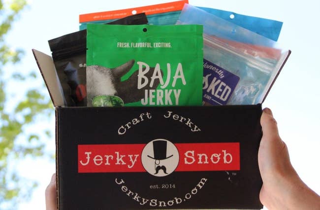 person holding box filled with assorted jerky 