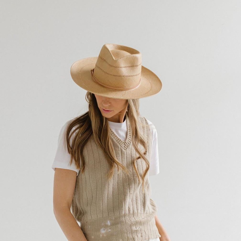 model wearing straw hat with a tie around the top