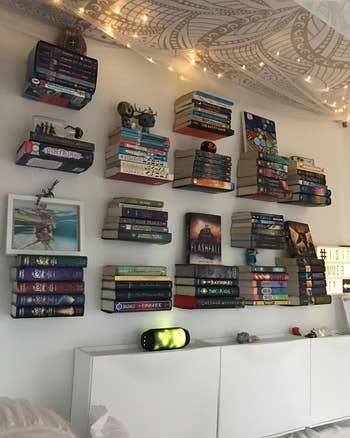 another reviewer's wall full of 14 floating shelves all holding a set of books