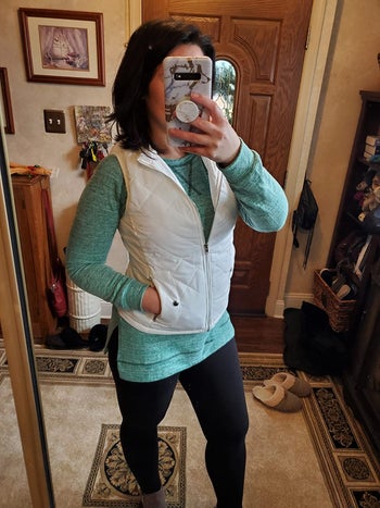 reviewer wearing the white quilted vest