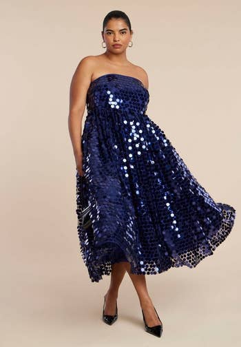 model successful  a strapless, sequined midi formal  with a flared skirt, holding a clutch, posing connected  a neutral background