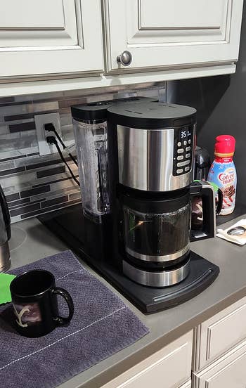 same reviewer showing the tray extended outward so the coffee maker is more accessible