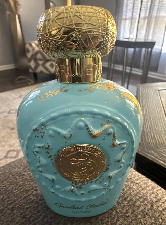 Blue perfume vessel with golden accents and ornate cap, displayed connected a table. The article's absorption is shopping