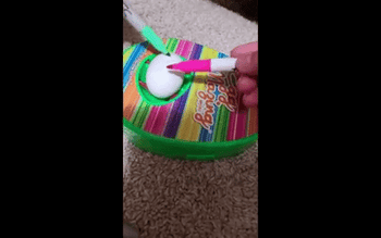 gif of the eggmazing with an egg spinning inside as someone draws on it with pink marker