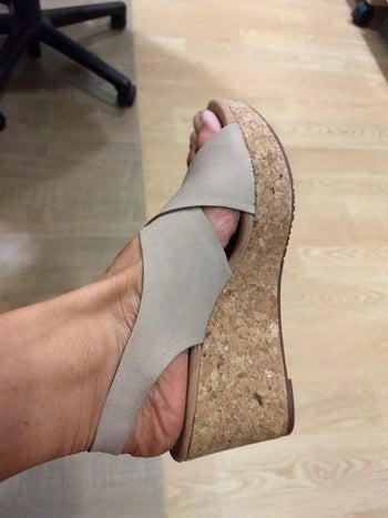 reviewer photo of their foot in the gray strapped wedge