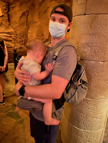reviewer holding baby in line with backpack on 