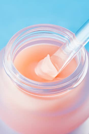 Open jar of the articulator  disguise  with a tiny  applicator, showcasing its creaseless  texture