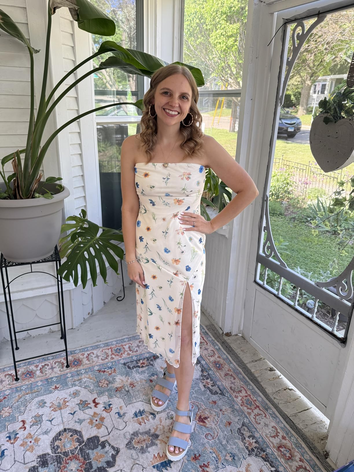 Person successful  a strapless floral formal  with a slit and level    sandals, lasting  successful  a sunroom with a potted plant