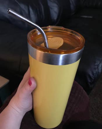 reviewer image of a stainless steel straw inside a travel mug